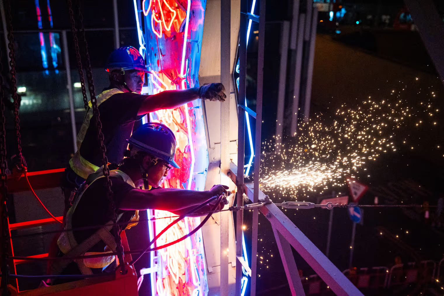 Construction workers remove a neon sign from a restaurant in Hong Kong. Bertha Wang / AFP